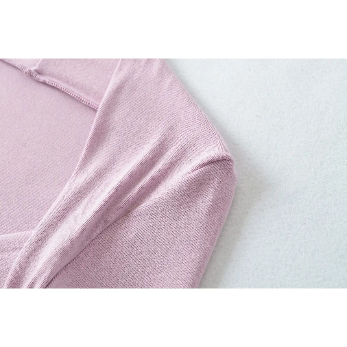 Macro closeup of lilac stretch knit fabric, soft texture of women twist front long sleeve top