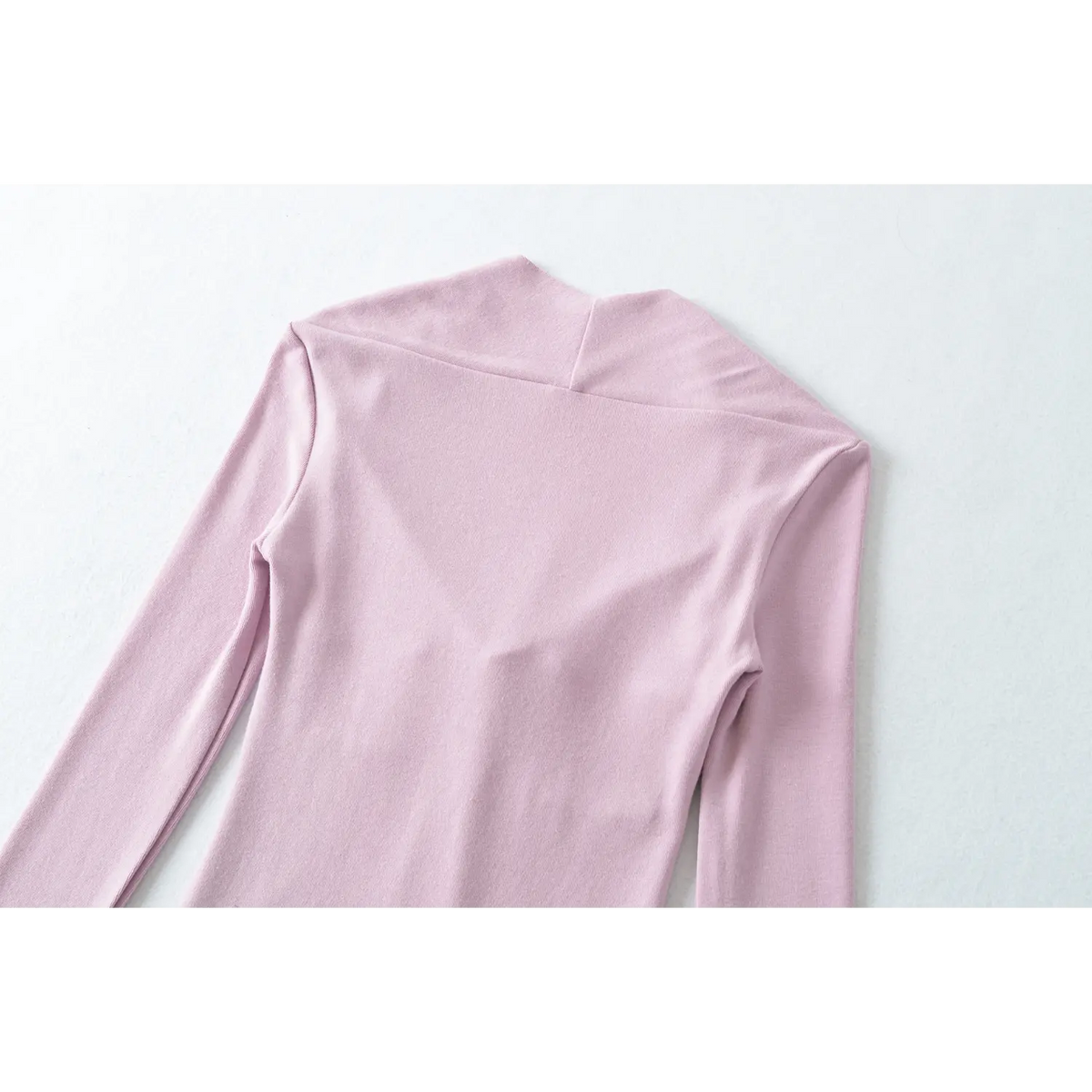 Partial shot of lilac long sleeve top back and shoulder, special wrap back neck design and smooth knit fabric