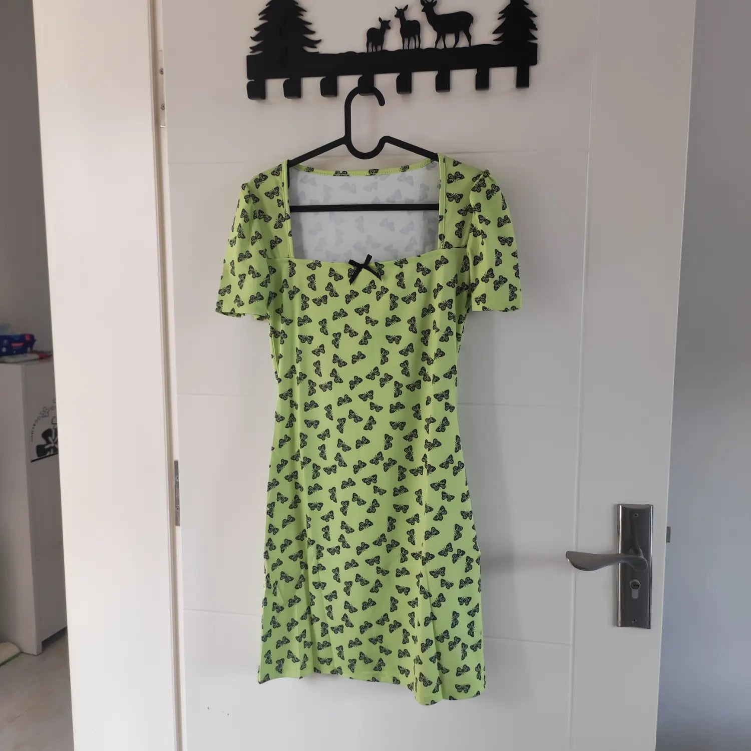 Hanging front view lime green square neck short sleeve bodycon dress all‑over black butterfly print