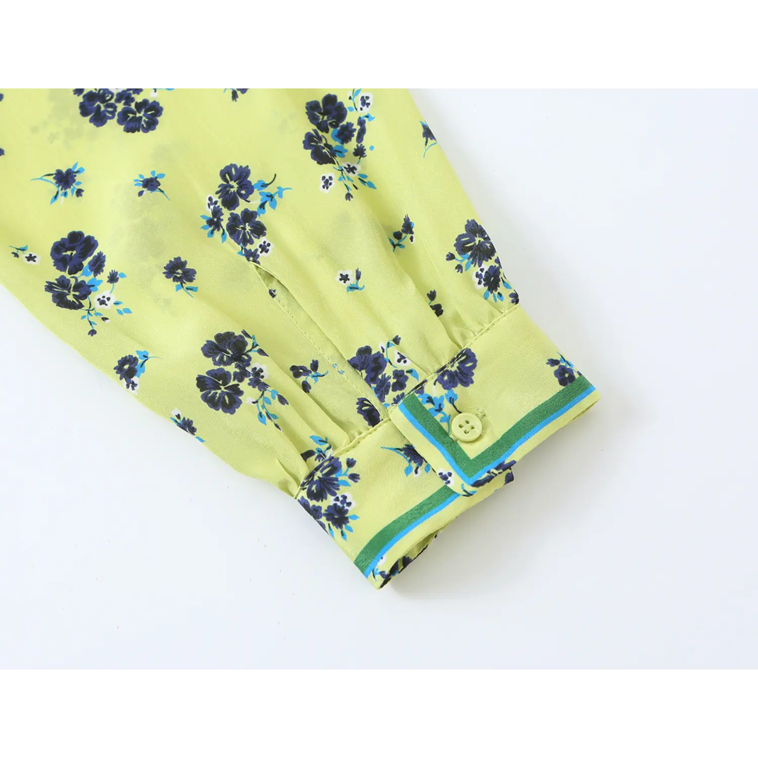 Close‑up shot sleeve cuff, button and contrast edge trim detail of lime green navy floral print blouse