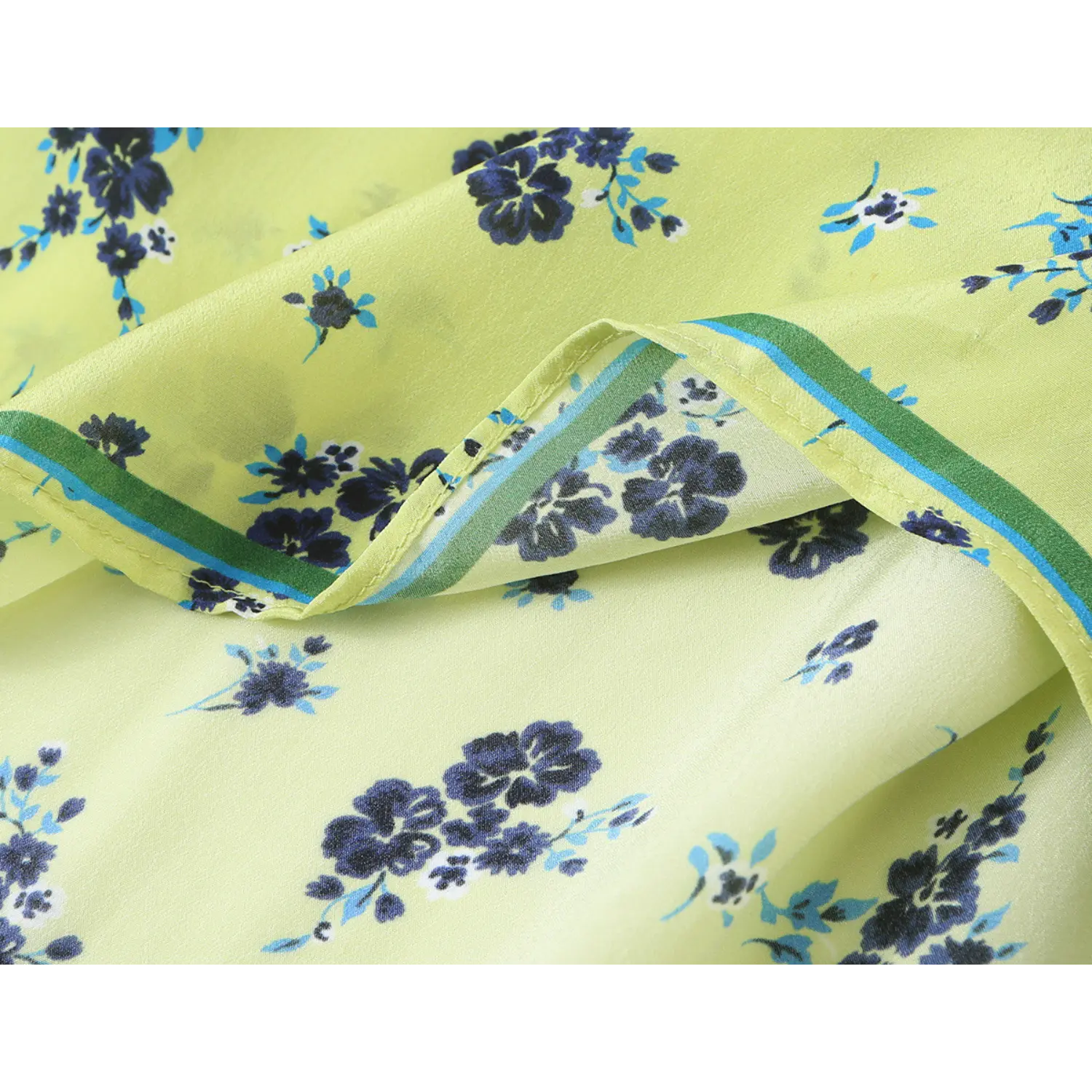 Close‑up layered fabric texture and edge piping trim on lime green floral printed blouse