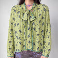 Model front view wearing lime green ditsy floral long sleeve blouse with neck tie bow detail