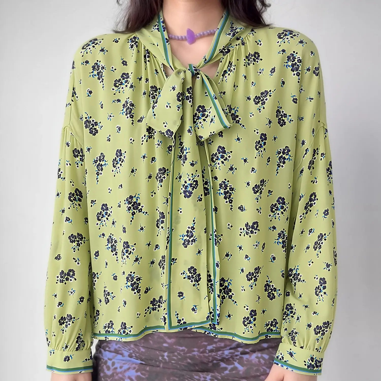 Model front view wearing lime green ditsy floral long sleeve blouse with neck tie bow detail