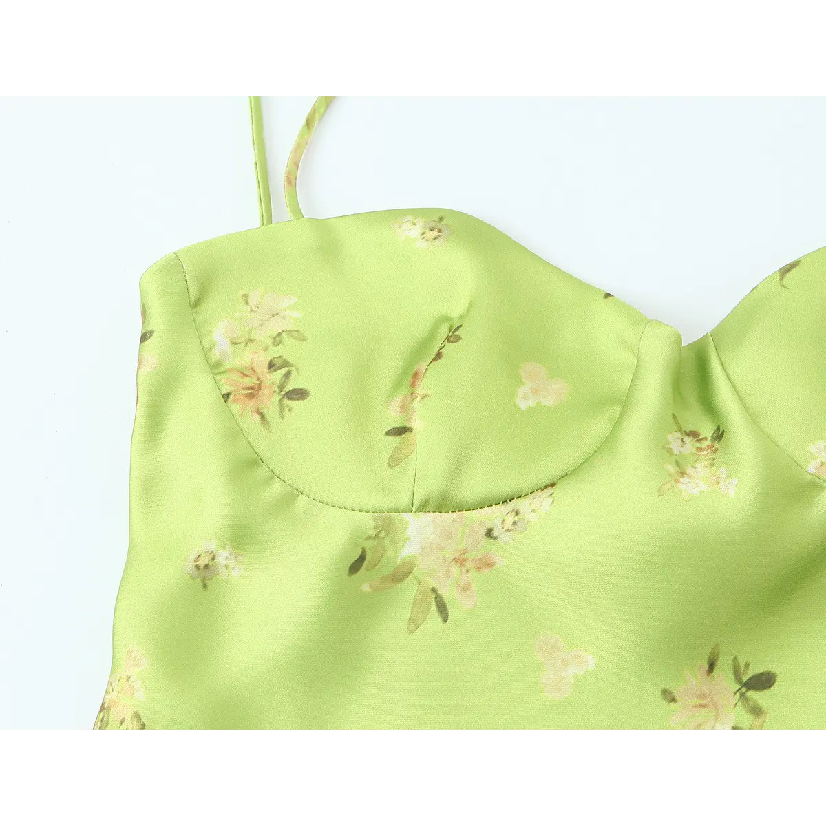Close-up of the sweetheart bodice on the lime green floral satin dress, showing the delicate stitching and watercolor-style print