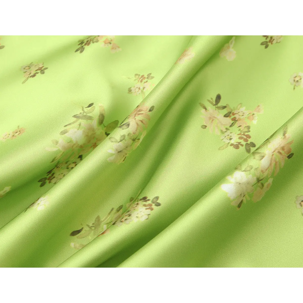 Fabric close-up of the lime green floral satin dress, highlighting the smooth texture and scattered floral pattern