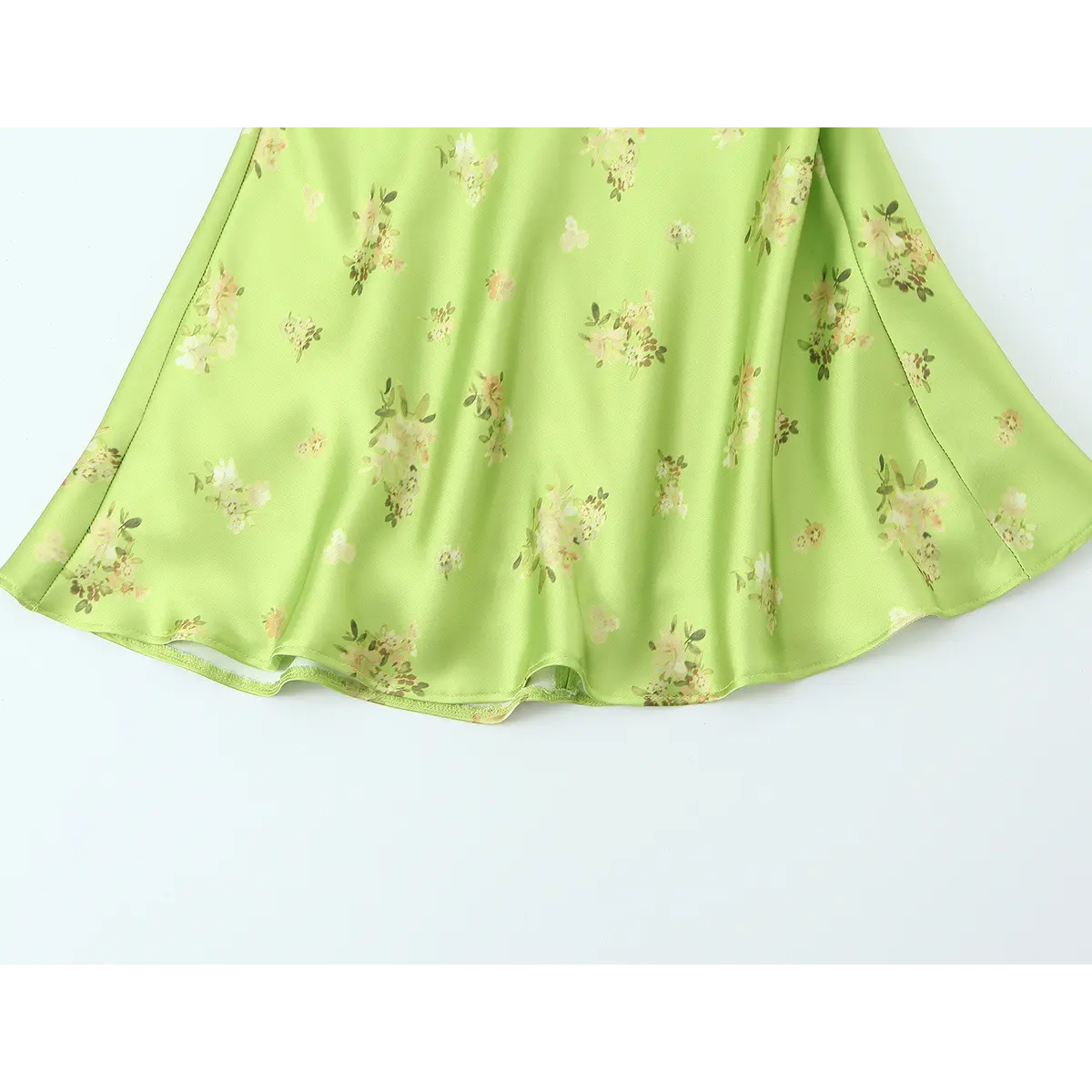 Hem view of the lime green floral satin dress, showing the flowy, bias-cut skirt and clean finish