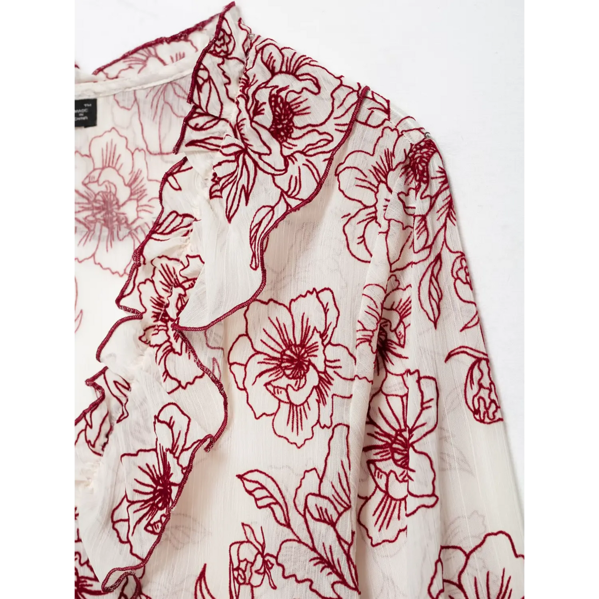 Close-up of ruffle edge and line art floral print