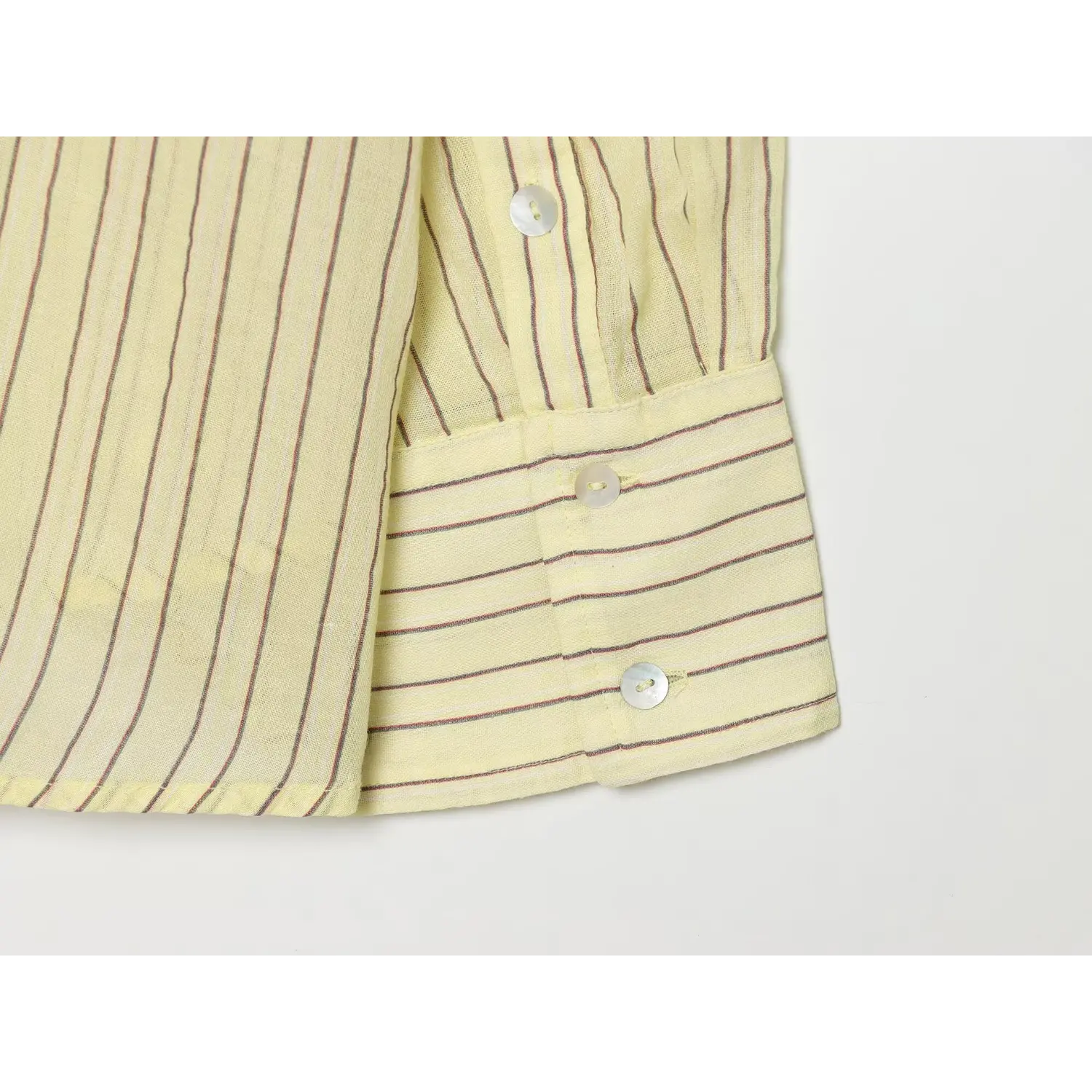 Detail shot of double shell button cuff, folded cuff design, vertical stripe fabric