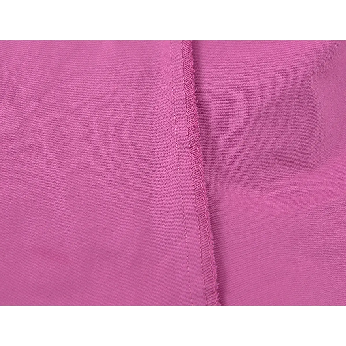 Close-up of the fabric texture and seam stitching on the magenta halter dress