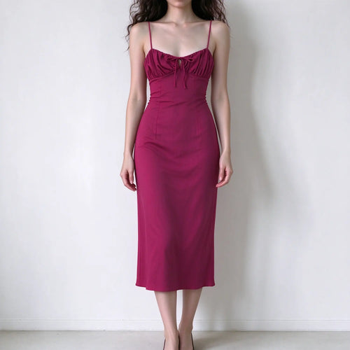Model wearing magenta spaghetti strap maxi dress, ruched bust with front tie detail, slim bodycon fit, smooth fabric, elegant maxi silhouette