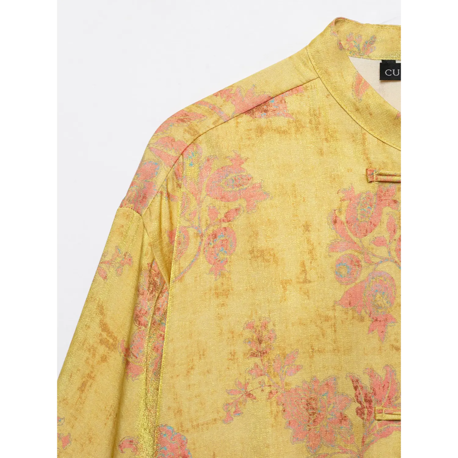 Close-up shoulder texture, faded pink floral print on golden yellow traditional chinese top