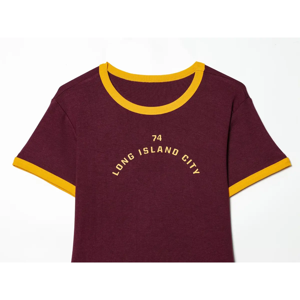 Full front view of maroon ringer t-shirt, featuring yellow "74 LONG ISLAND CITY" print and matching sleeve trim