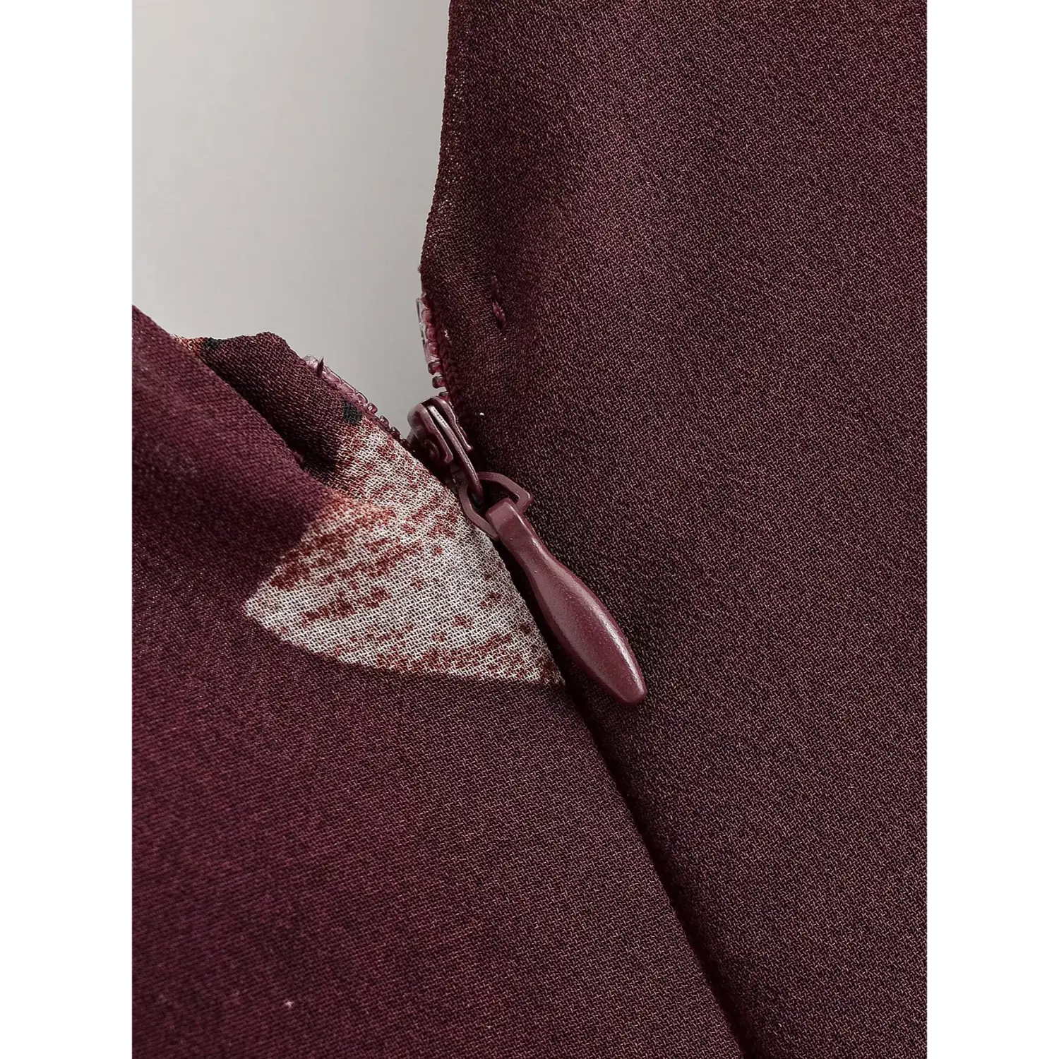 Extreme closeup burgundy invisible zipper at center back