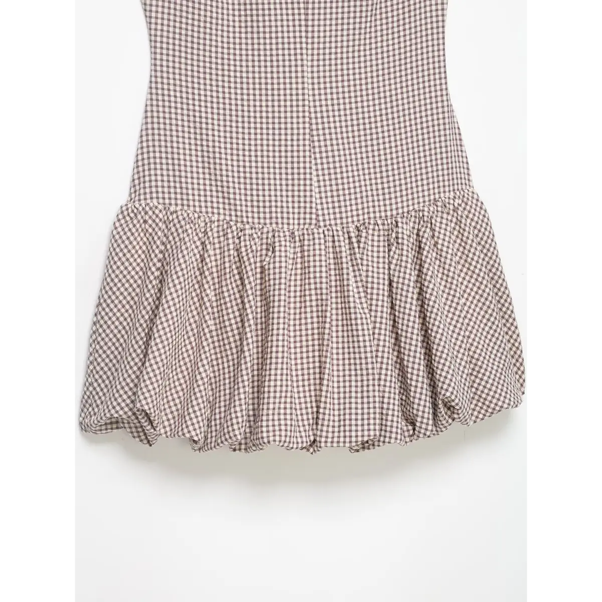 Hem detail of the mauve gingham dress, showing the gathered tiered skirt and bubble hem