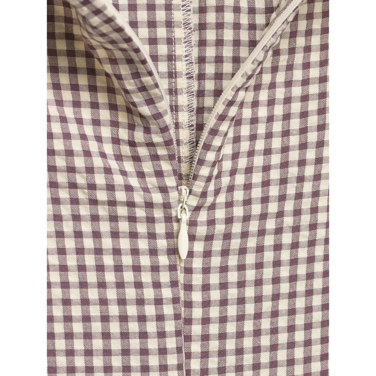 Close-up of the white zipper on the mauve gingham dress, showing the matching fabric placket and zipper pull