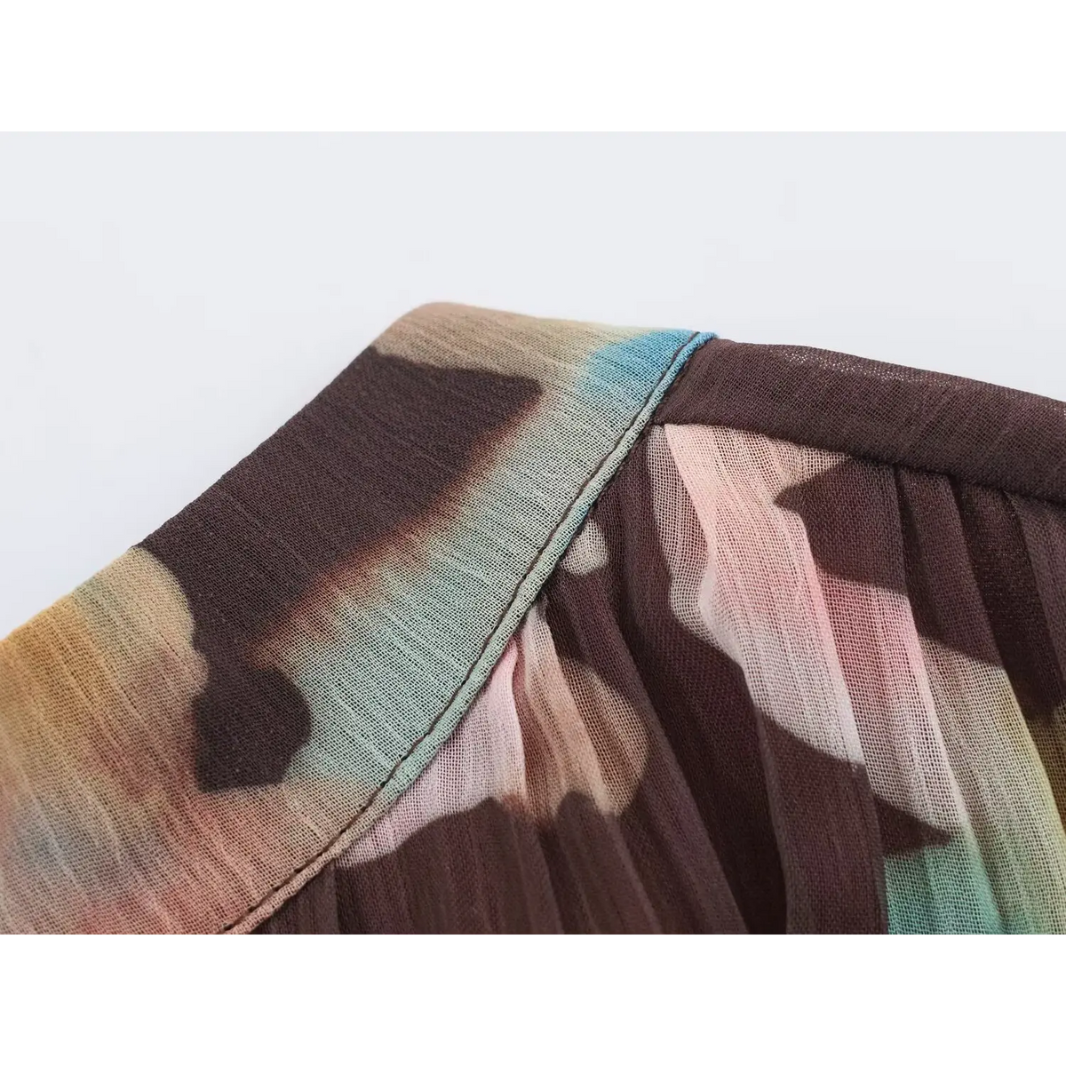 Close-up of drawstring cuff with mixed-color ties on long balloon sleeve of watercolor maxi dress
