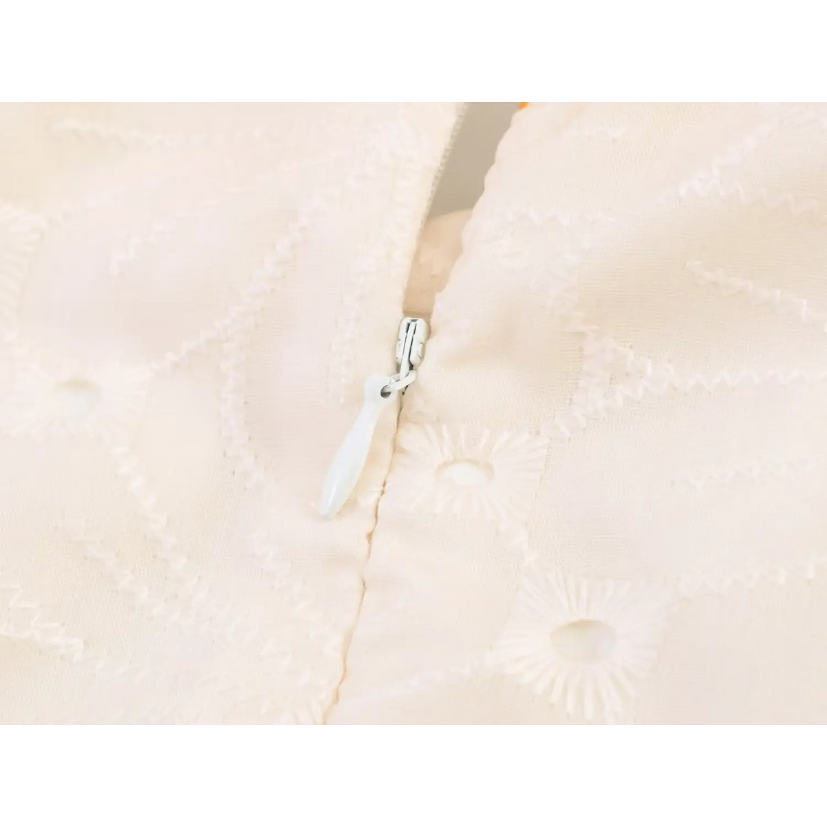Macro shot of invisible back zipper on eyelet embroidered long maxi dress
