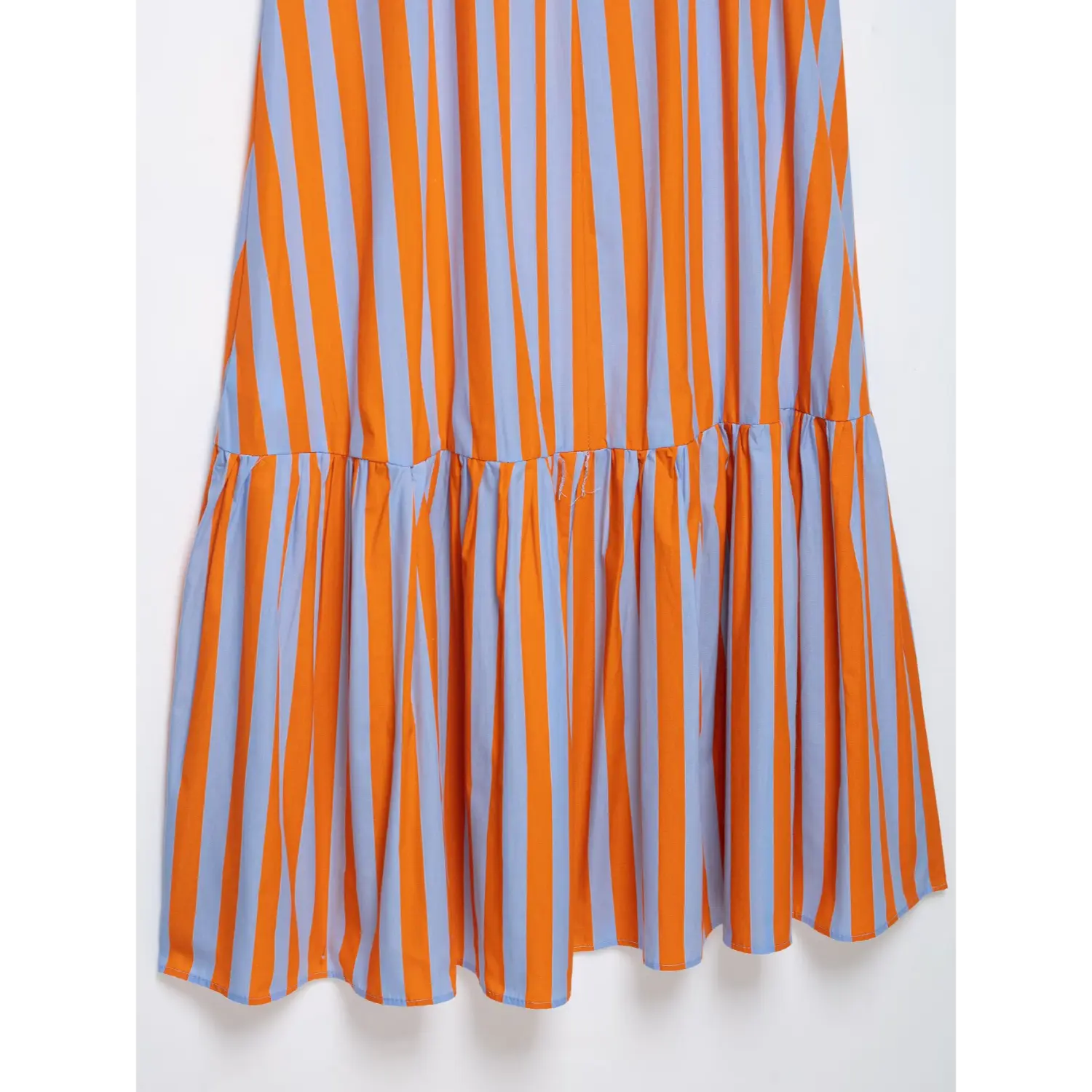 Close-up gathered ruffle hem skirt of orange and light blue vertical stripe maxi sundress