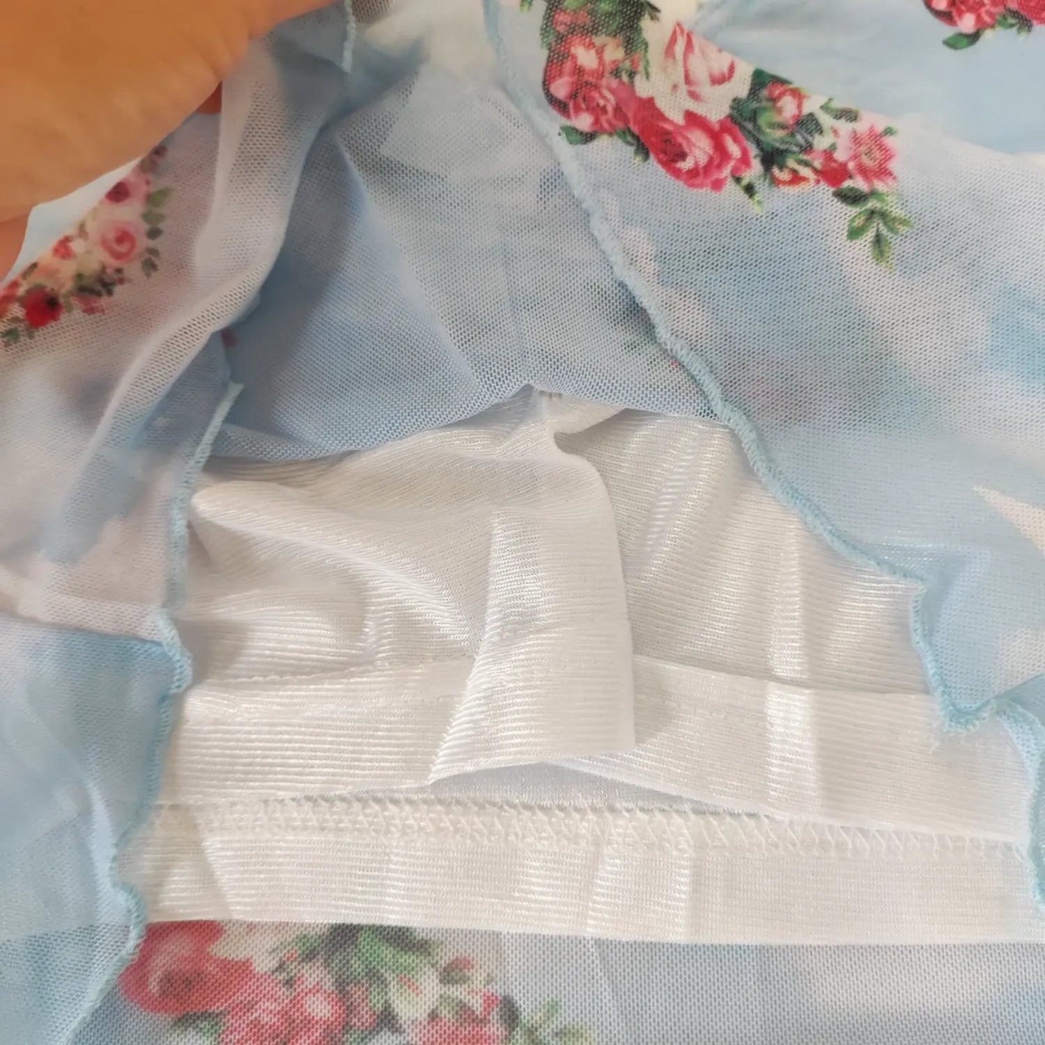 Close‑up inner lining and stitching seam detail of light blue angel print mesh crop top