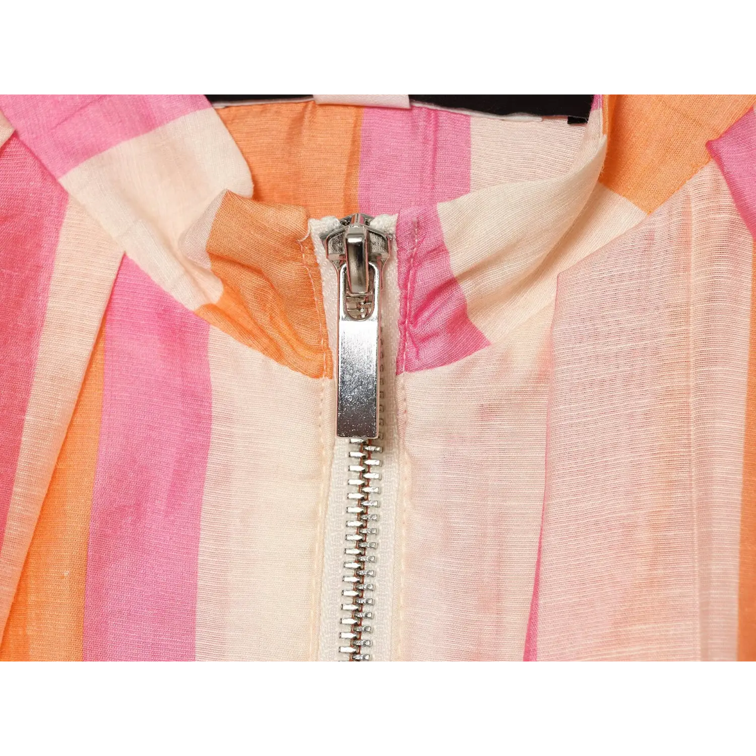 Front zipper macro close-up, silver metal zip puller, tape edge stitching, orange pink stripe fabric