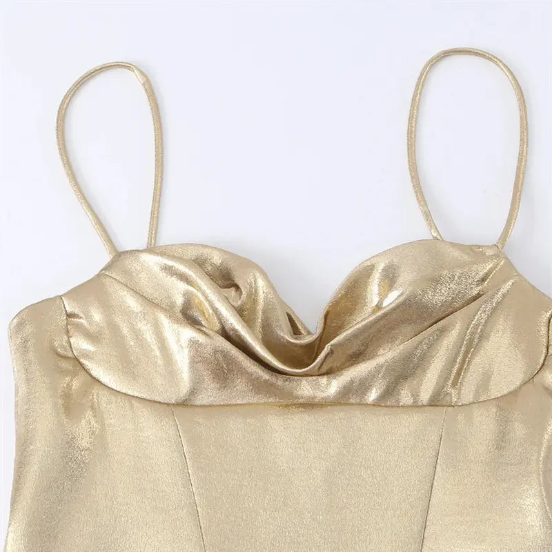 Closeup cowl draped ruched neckline, glossy metallic gold fabric sheen, thin matching spaghetti strap shoulder