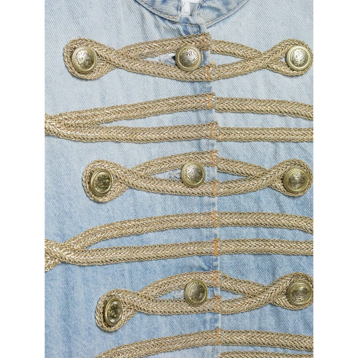 Macro close-up antique engraved metal buttons and metallic woven braid trim on denim jacket front placket