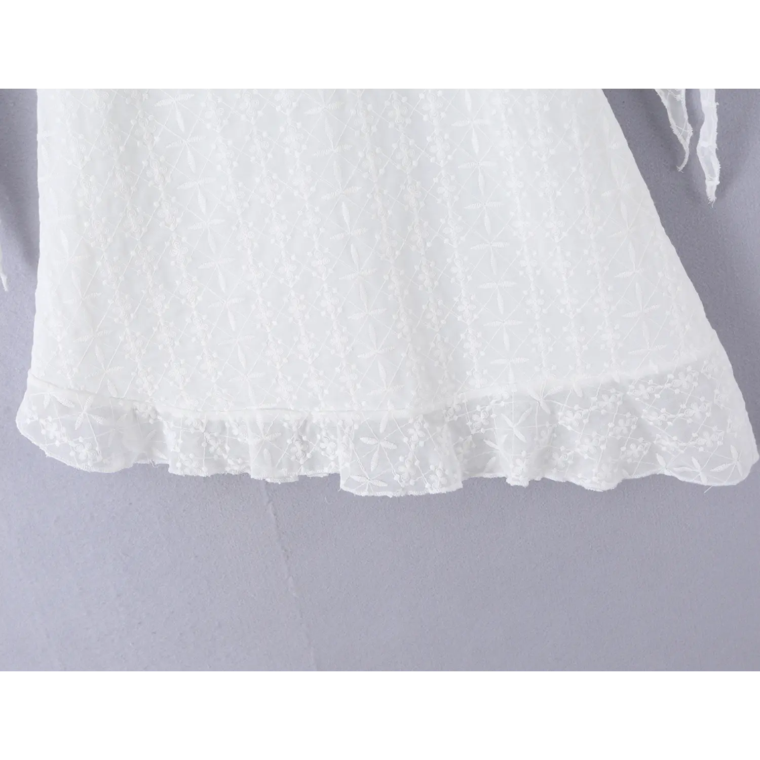Mini dress irregular ruffle skirt drape flat overview shot, full floral eyelet embroidery natural wavy hem slimming short silhouette display