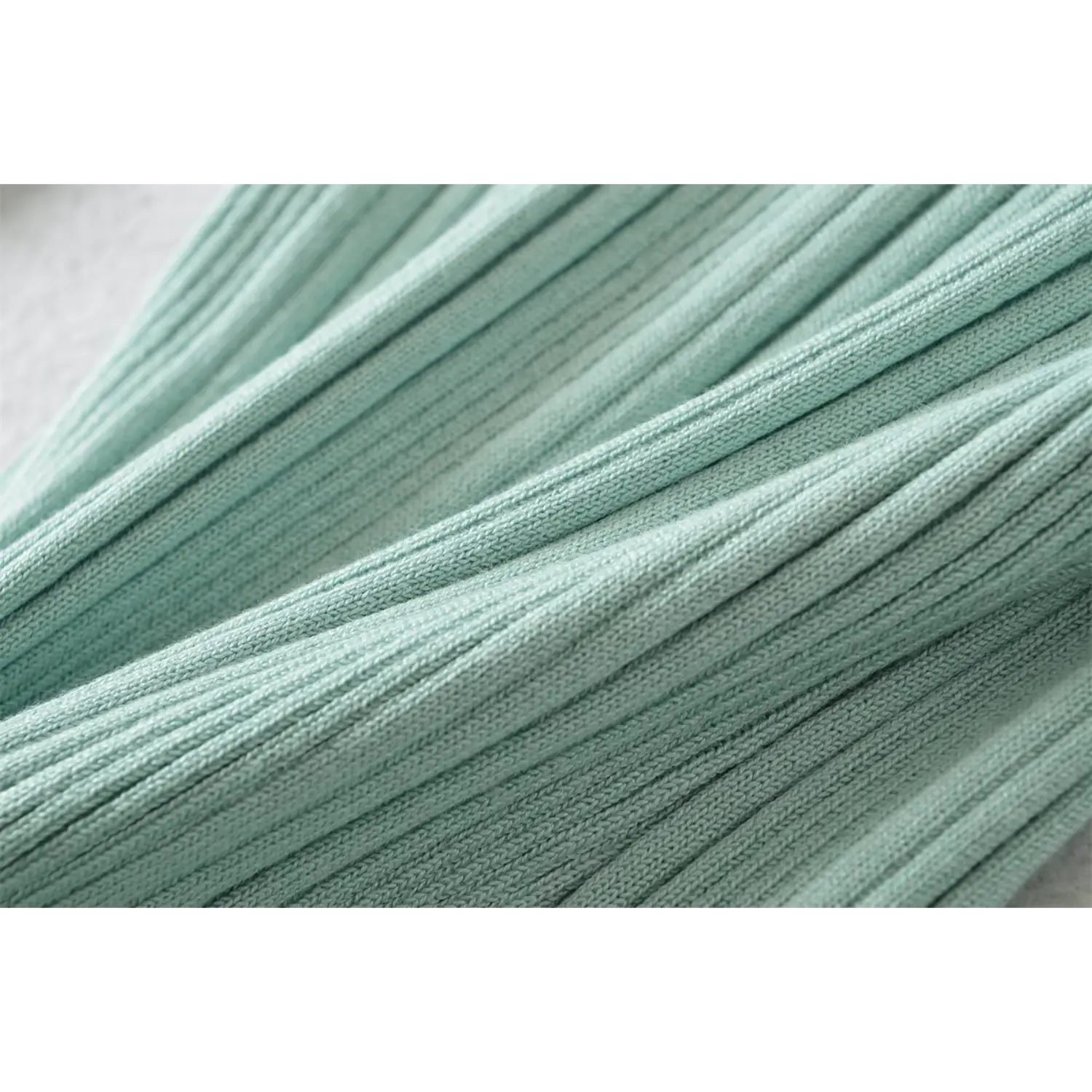 Fabric macro closeup, mint vertical rib knit material, stretch texture display
