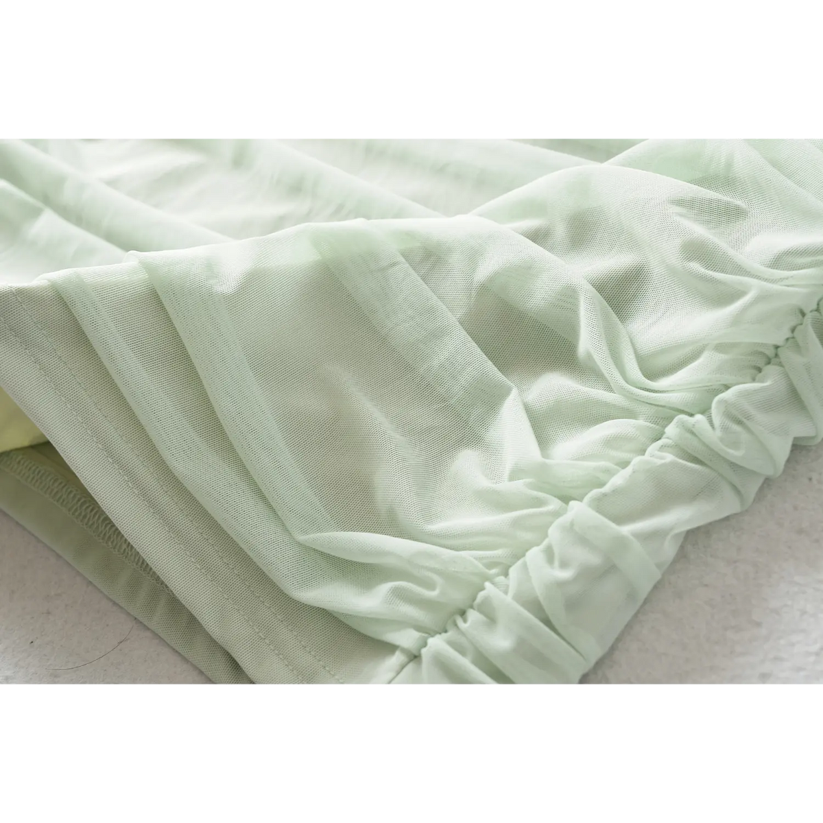 Mint green mesh fabric texture closeup, stretch ruched material for bodycon dress