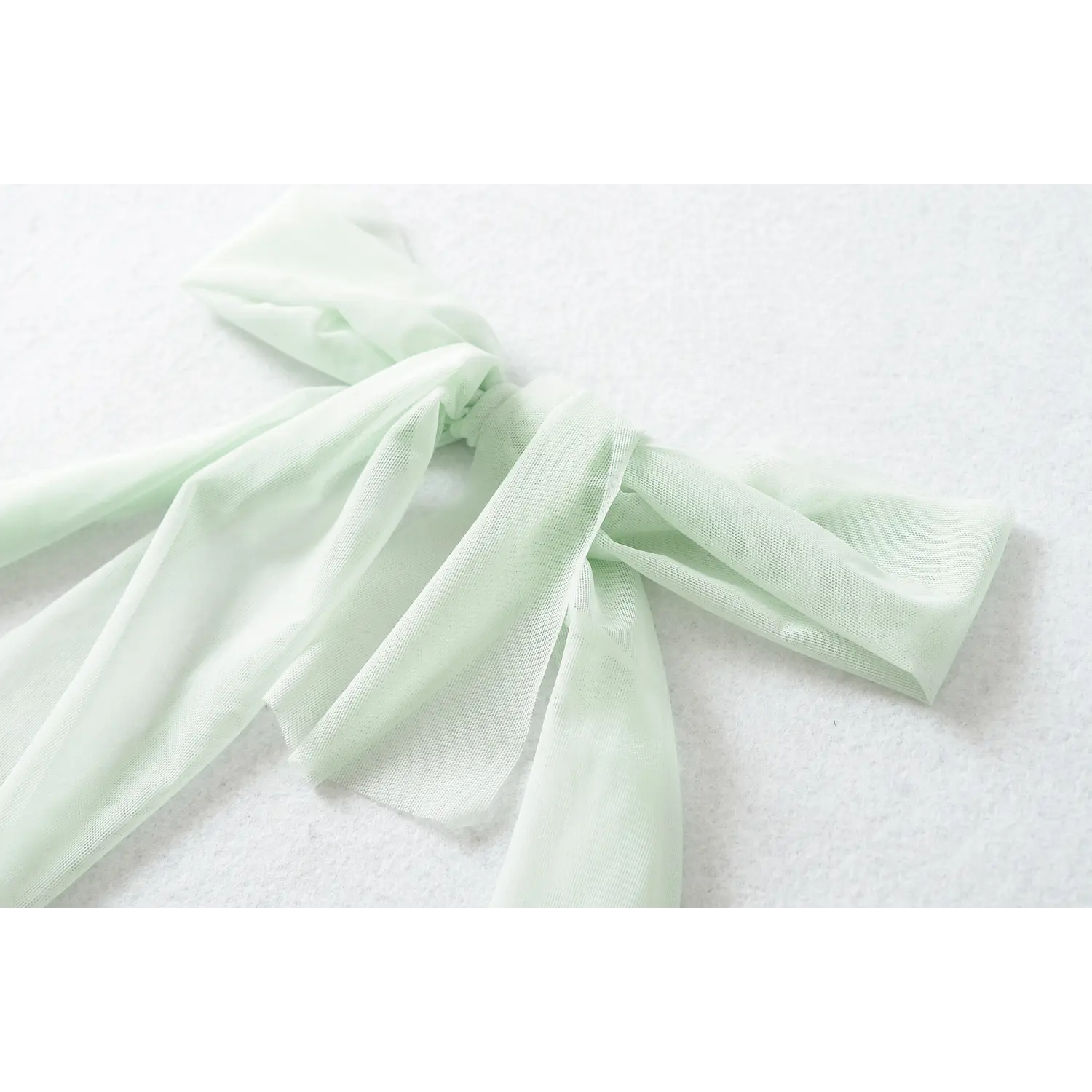 Close-up shot of mint green mesh halter neck bow, soft sheer fabric