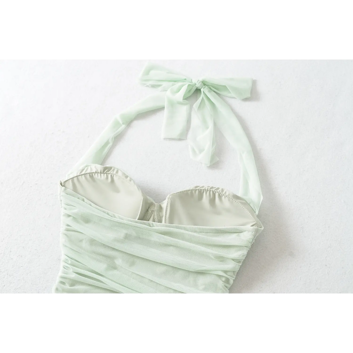Close-up view of mint green halter mini dress sweetheart padded bust and mesh halter bow