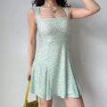 Woman wearing a mint green leopard print flare dress, accessorized with a butterfly necklace, showcasing the dress's square neckline and texture.
