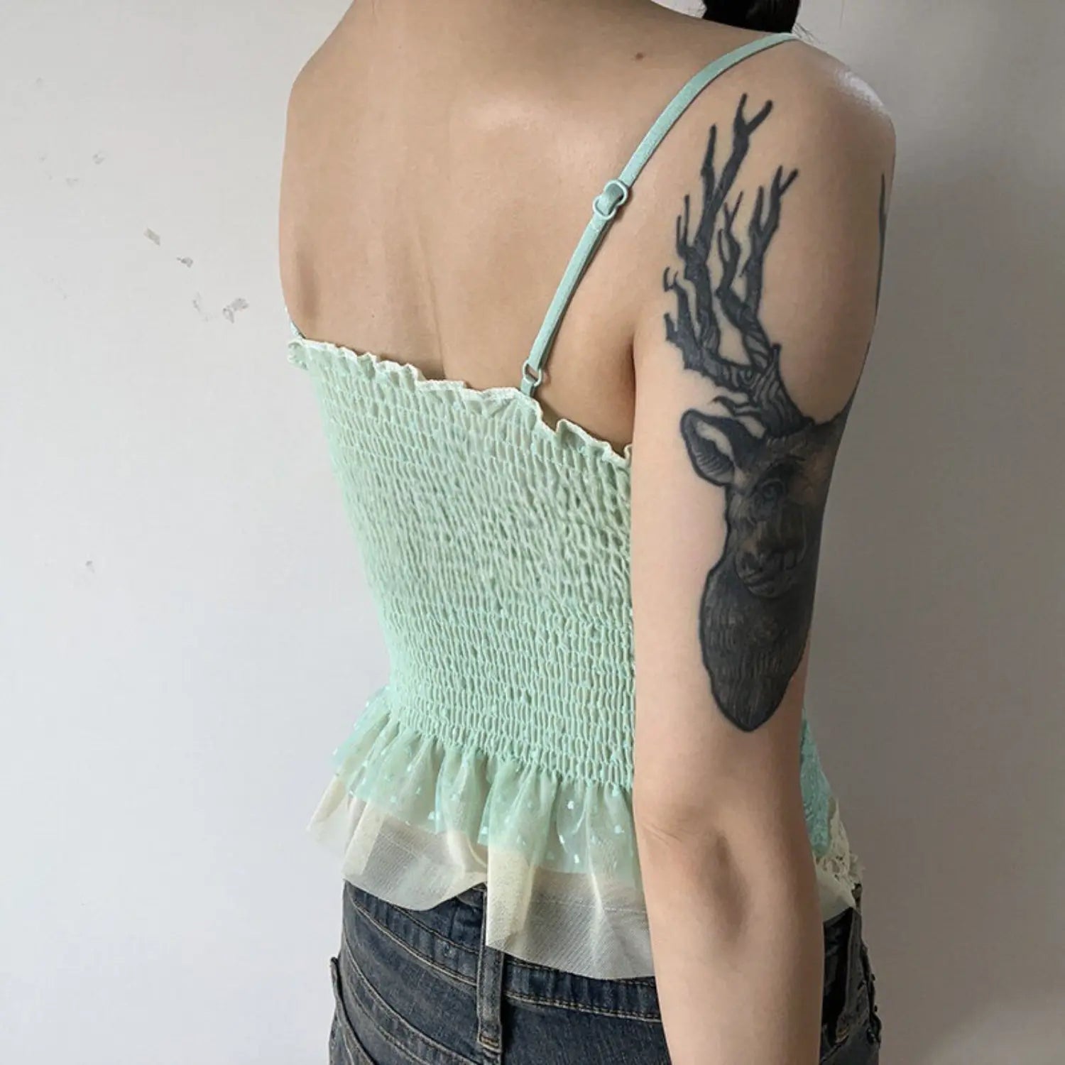 Mint green polka dot mesh lace cami tank back model indoor shot, full elastic smocked back ruffle mesh hem, adjustable thin straps matched with denim shorts casual outfit