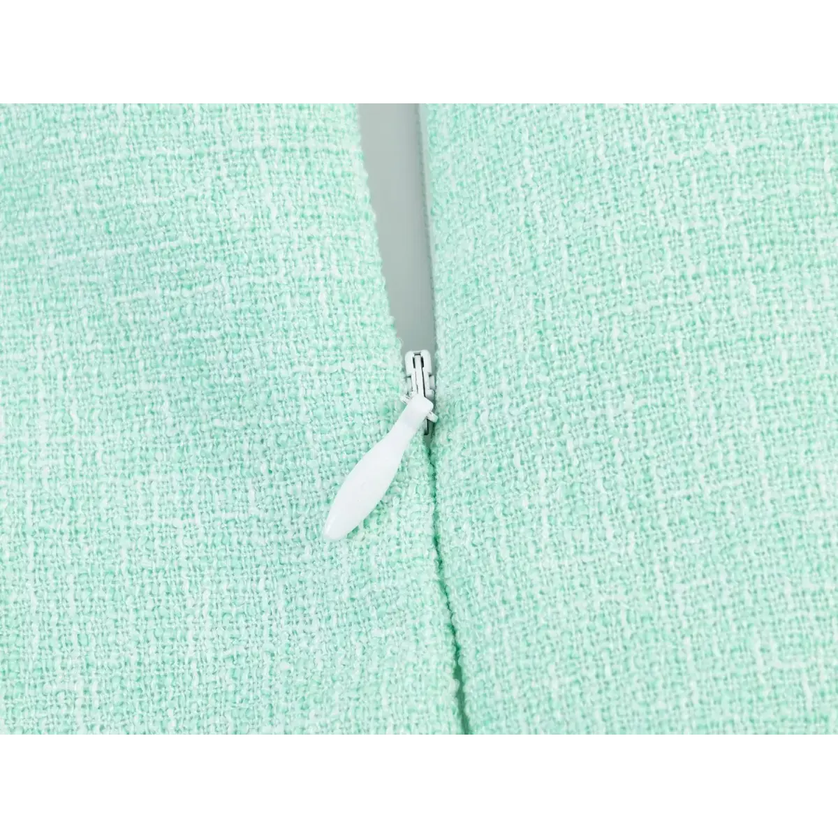Close-up of the invisible side zipper on a mint green tweed sleeveless dress.
