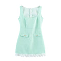 Full front view of a mint green tweed sleeveless mini dress, featuring faux pockets with gold buttons and decorative petal hem trim.
