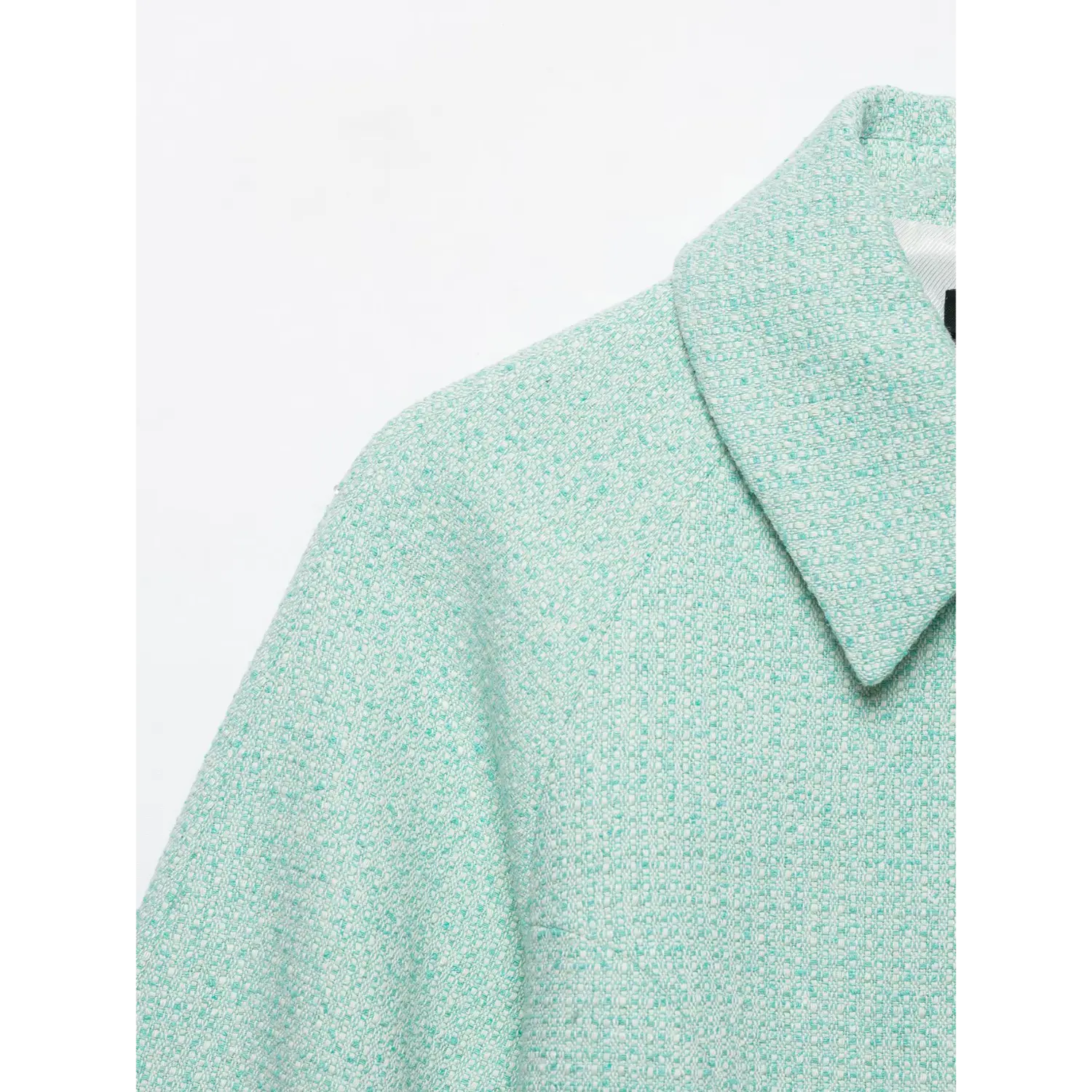Close-up shot mint green tweed cropped jacket, lapel collar and shoulder fabric texture detail