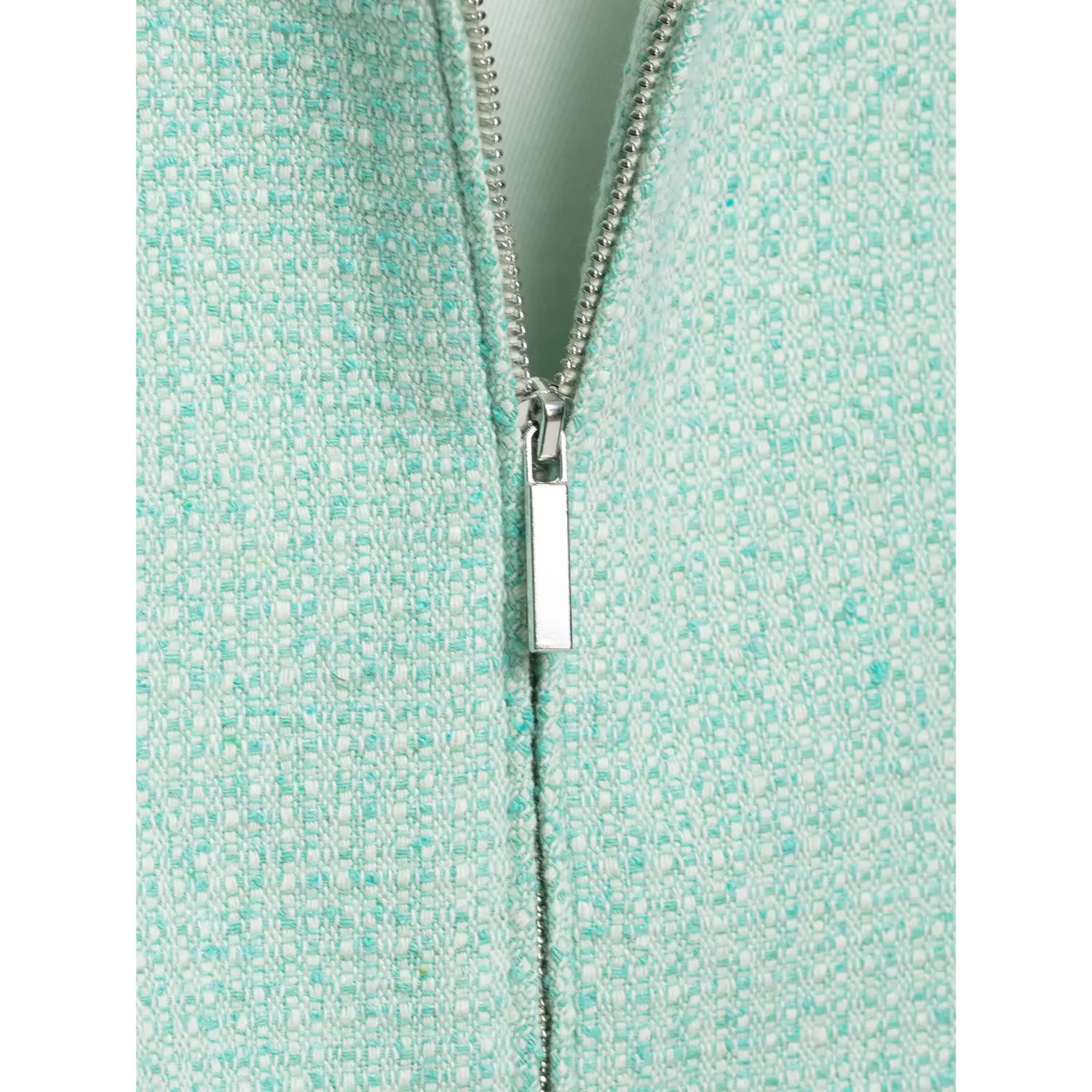 Close-up view silver metal zipper pull detail on mint green textured tweed cropped jacket