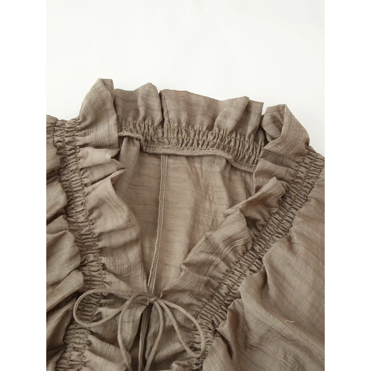 Close-up of smocked ruffle neckline and tie