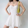Female model wearing white sweetheart spaghetti strap mini dress, fitted waist flowy skirt outfit