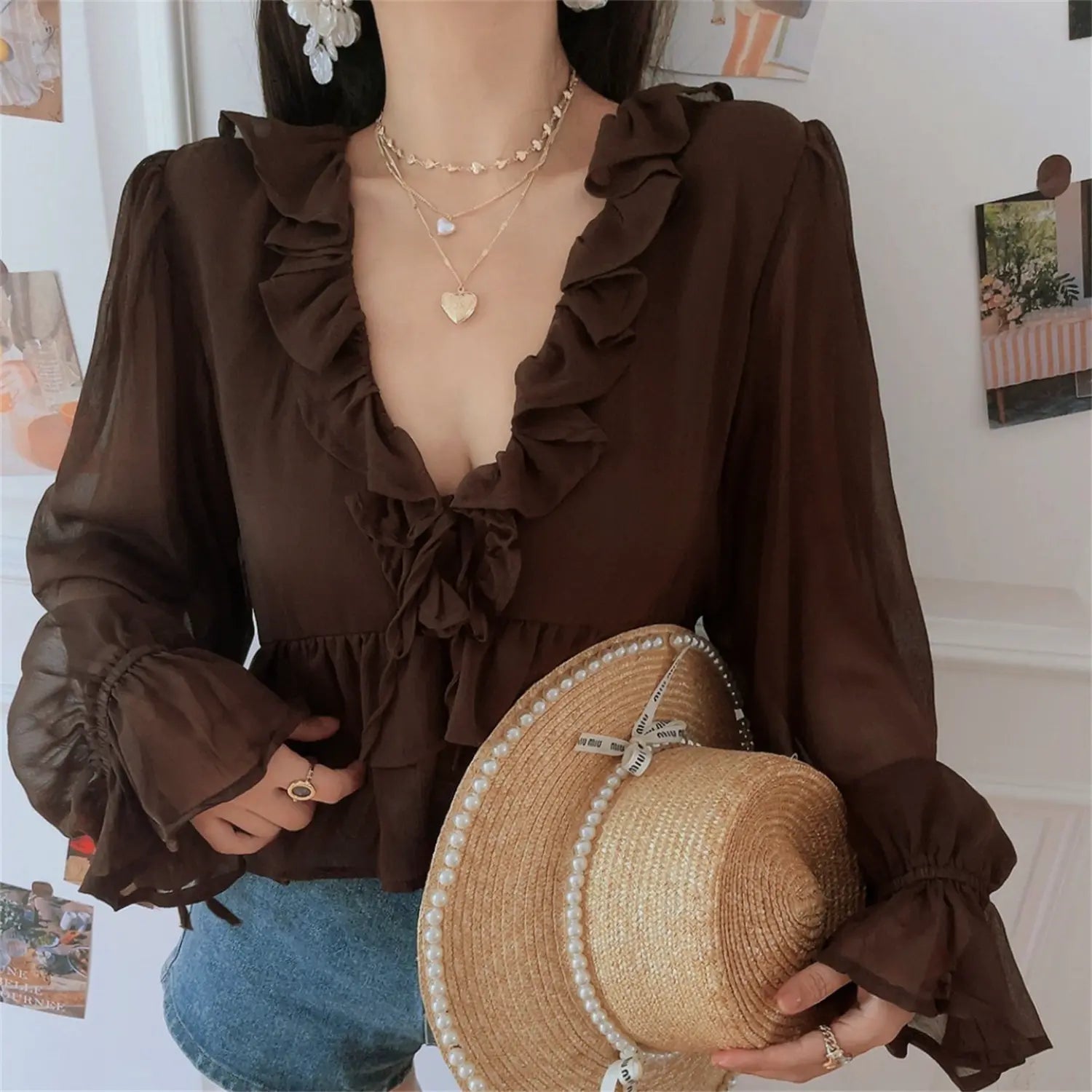 Moody caramel brown ruffle chiffon crop top low angle model shot, emphasize V neck frill front tie waist-cinched cropped silhouette soft feminine date travel outfit display