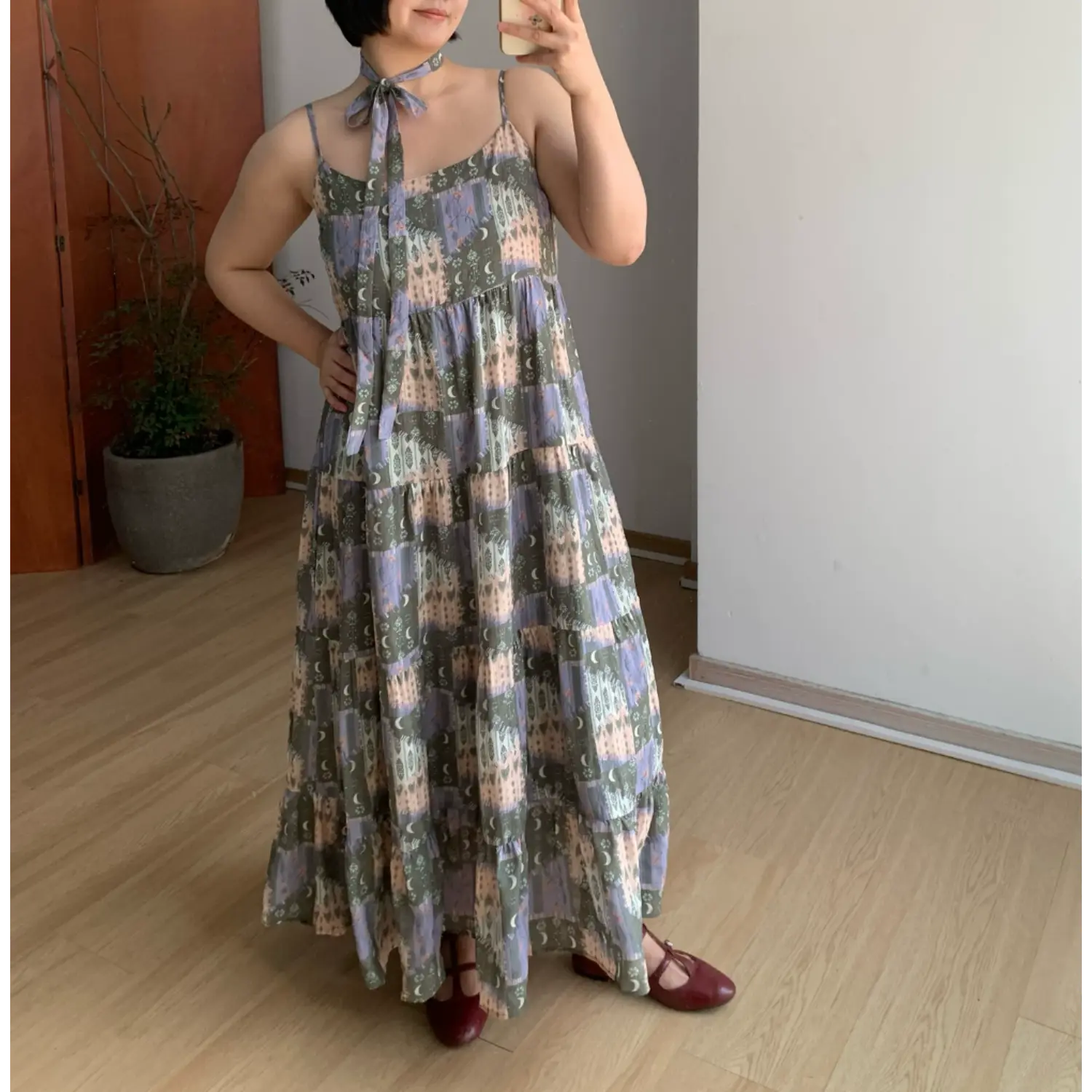 Olive green moon floral vacation cami tiered maxi dress, multi-layer ruffle loose silhouette, model hand on waist full body indoor display shot