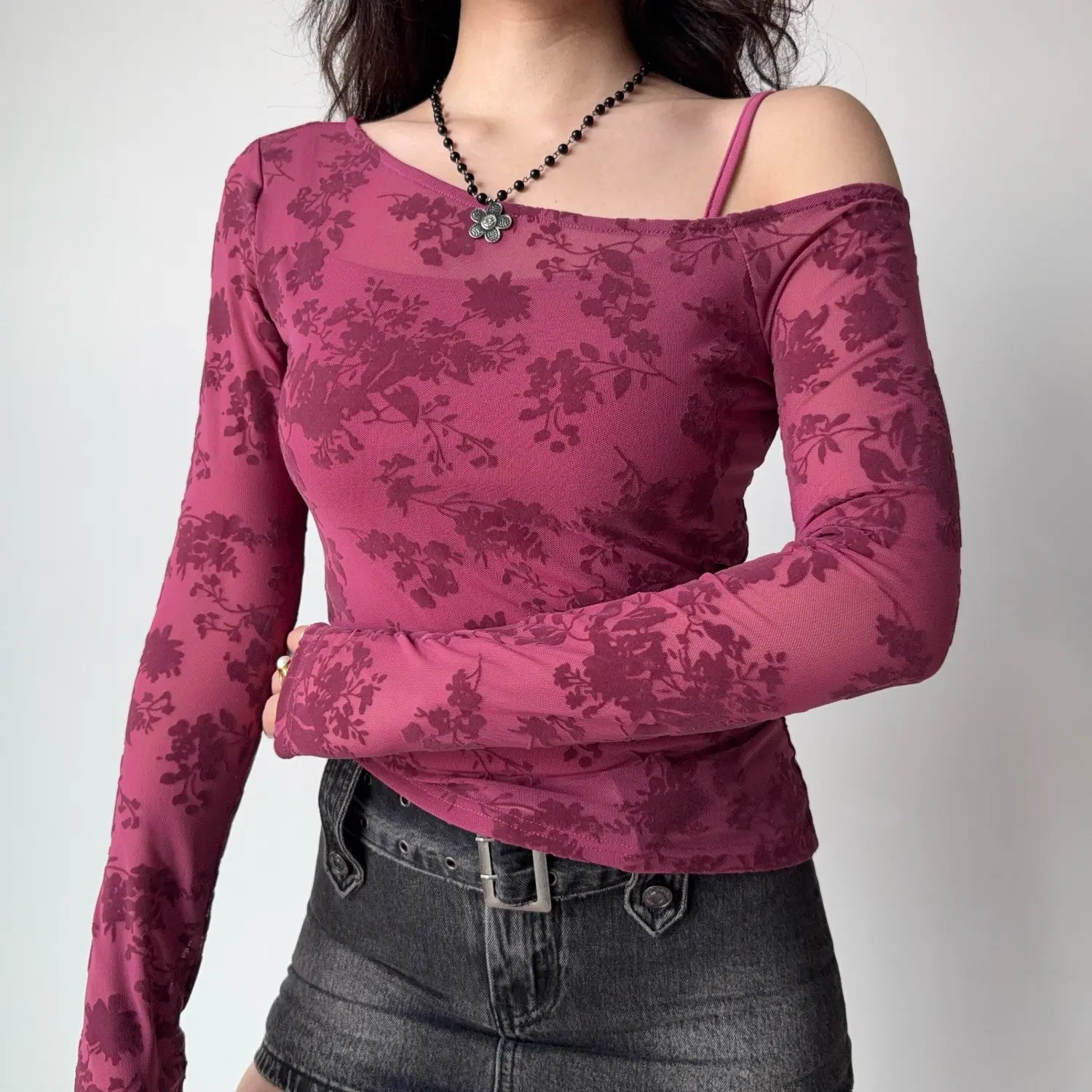 Model front view mulberry pink floral flock mesh long sleeve top asymmetrical off shoulder neckline with inner cami