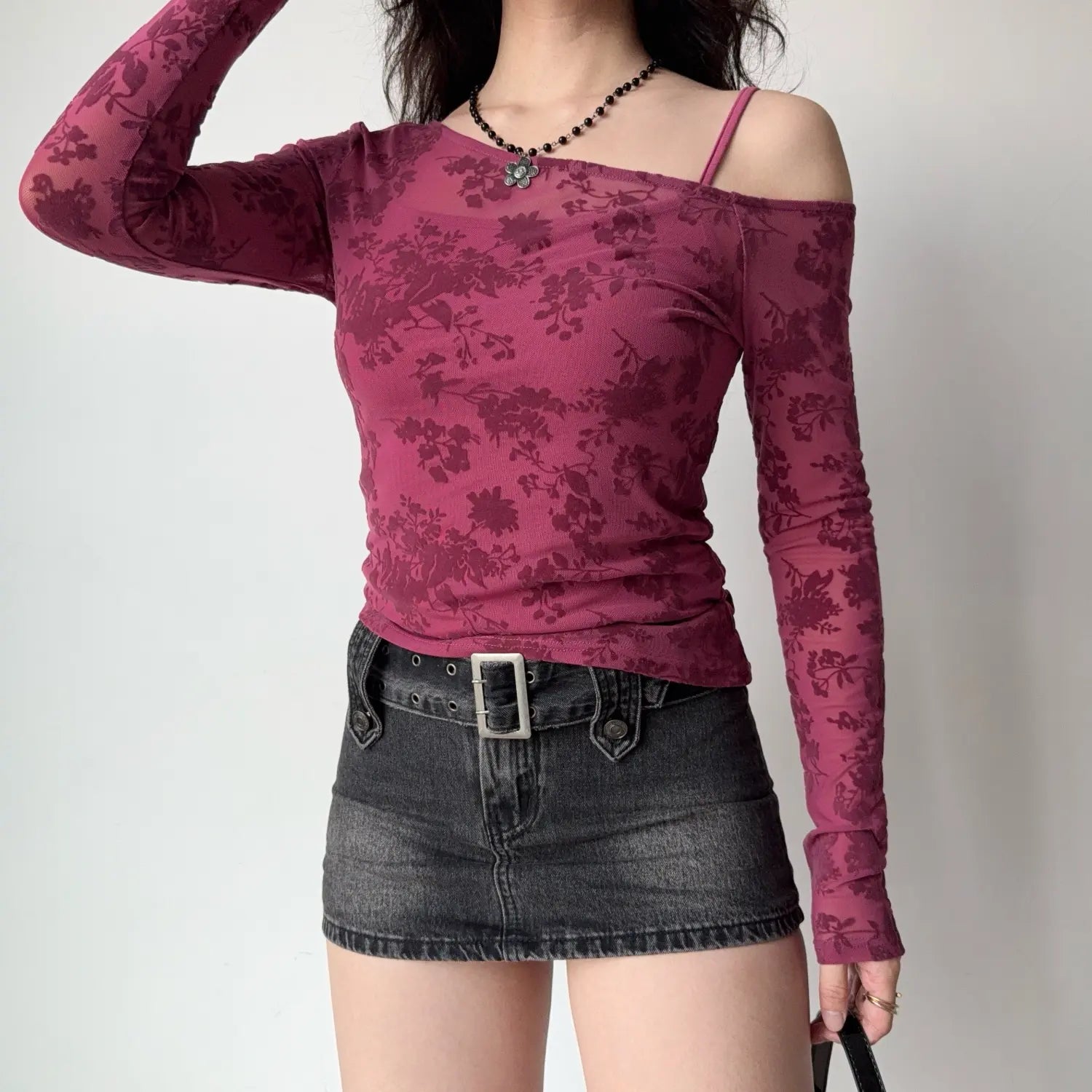 Full front model shot mulberry pink floral mesh off‑shoulder long sleeve top paired with denim mini skirt