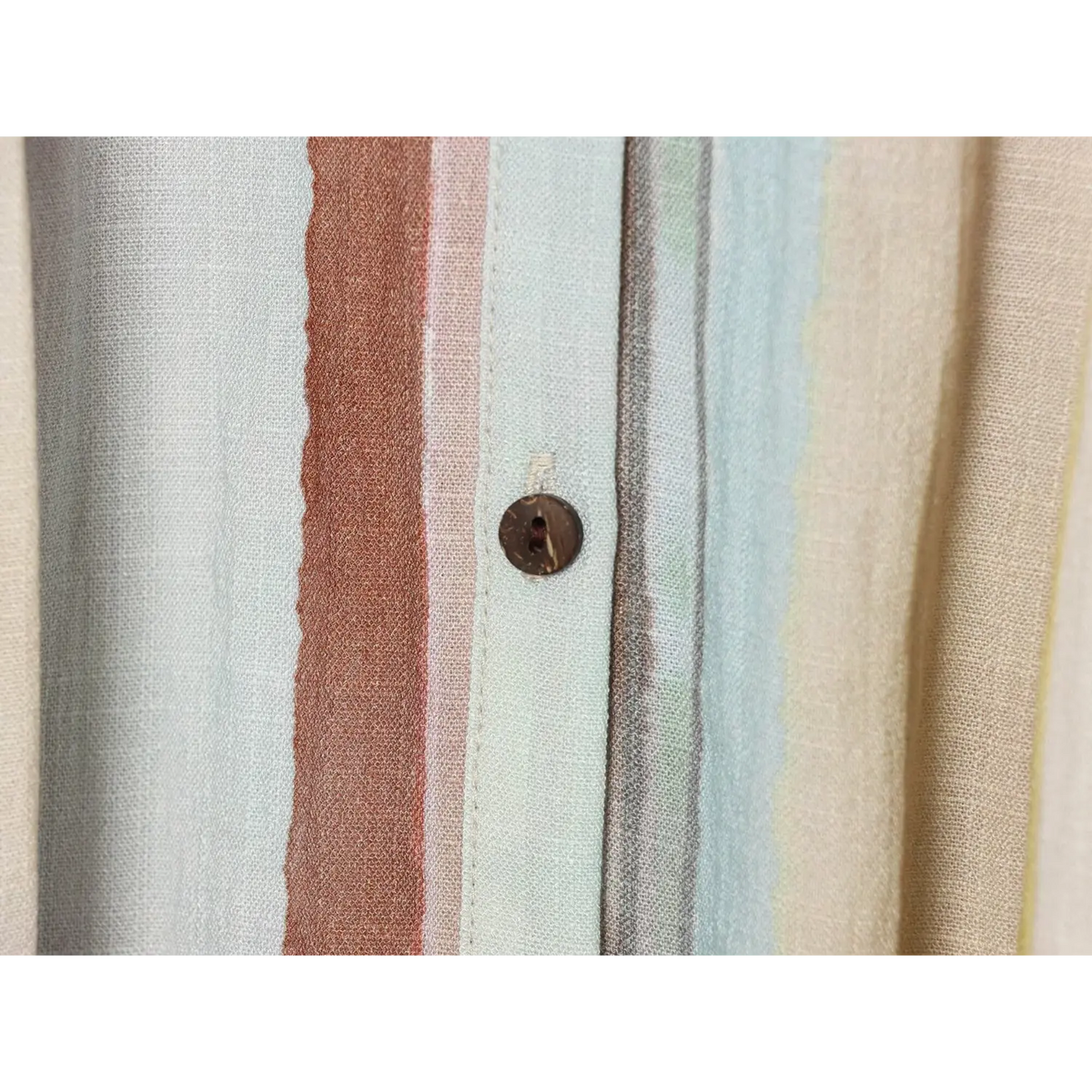 Macro close‑up of front button placket on multicolor stripe maxi dress