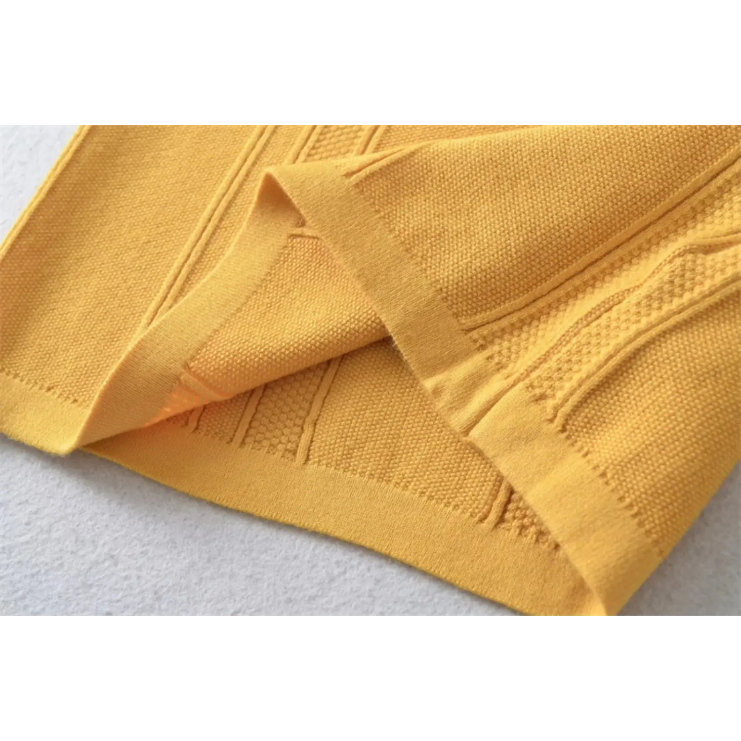 Mustard yellow vertical rib stretch knit fabric drape wrinkle macro flat shot, soft drape bumpy stripe texture white background detail