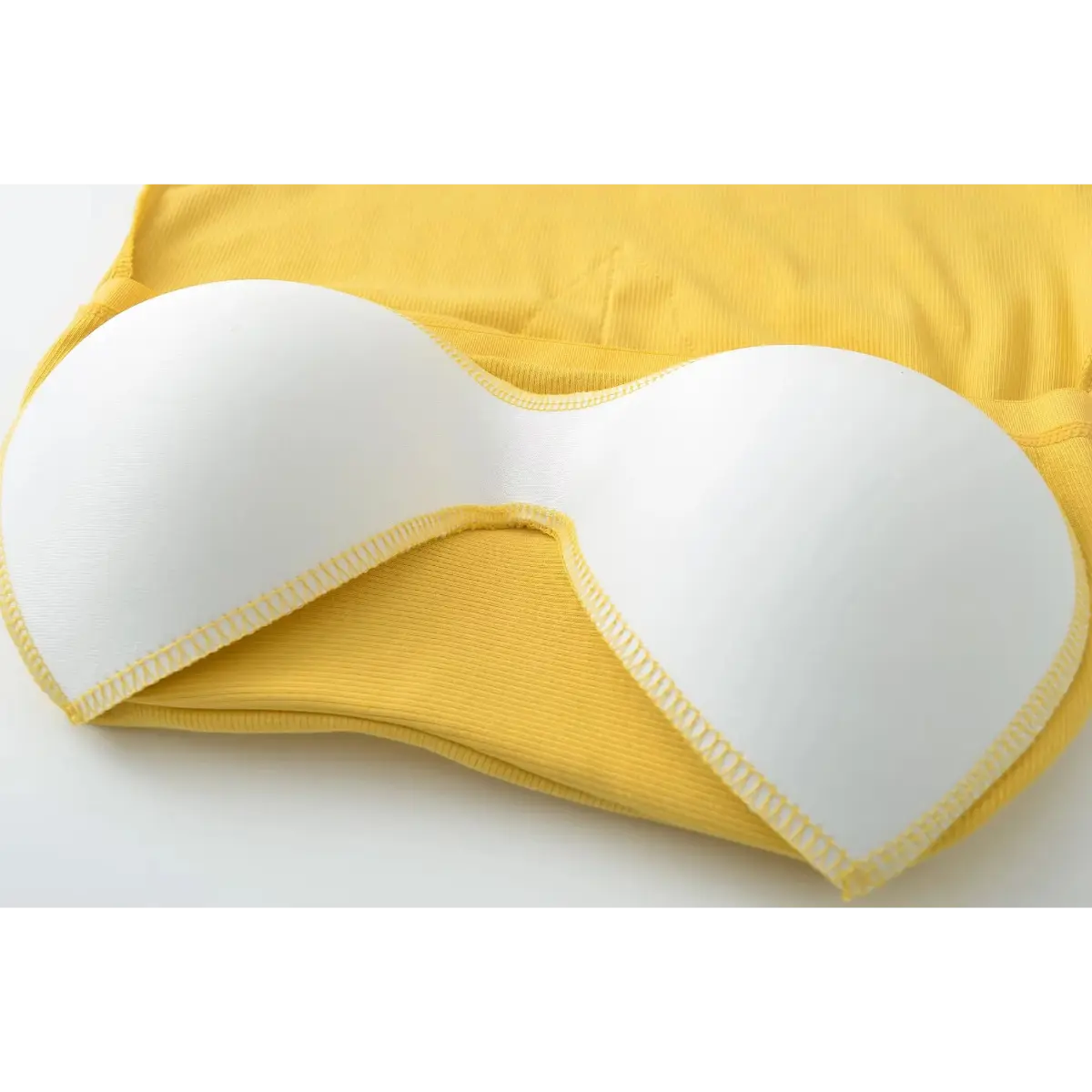 Close-up of the removable, contoured bra pad inside the mustard yellow camisole