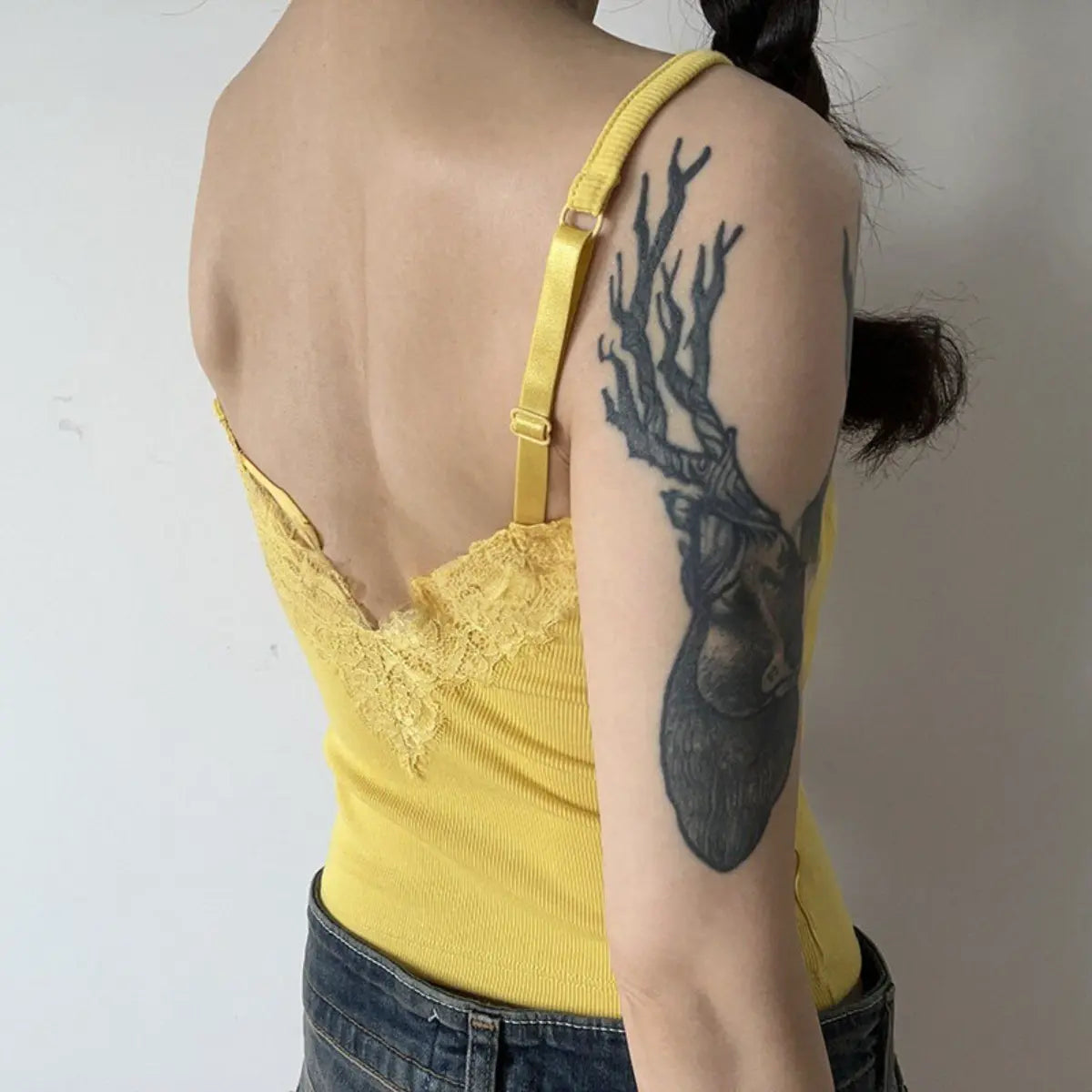 Back view detail shot of mustard yellow camisole, showing lace trim and adjustable straps