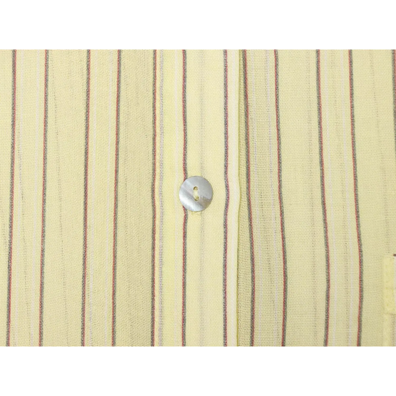 Extreme closeup of pearlescent shell button against lightweight striped fabric