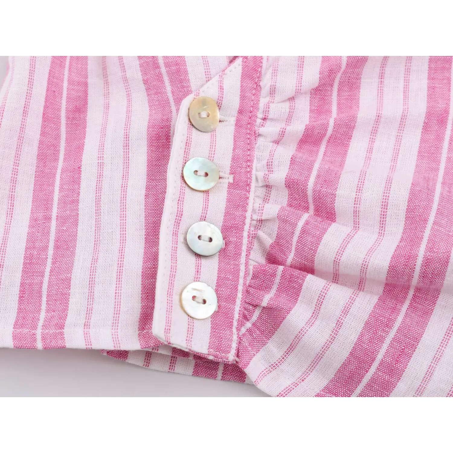 Fabric close-up of lightweight textured vertical stripe material and finished overlock inner stitching