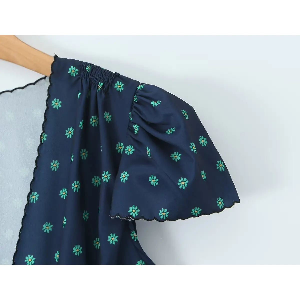 Close-up of the puffed short sleeve, featuring the elasticated gather and scalloped hem.